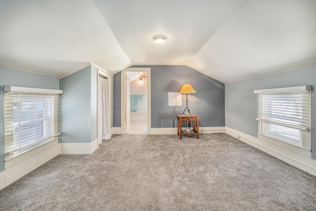 bonus room with vaulted ceiling and carpet flooring