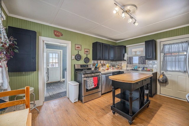 kitchen featuring sink, light hardwood / wood-style flooring, butcher block counters, stainless steel appliances, and a kitchen island