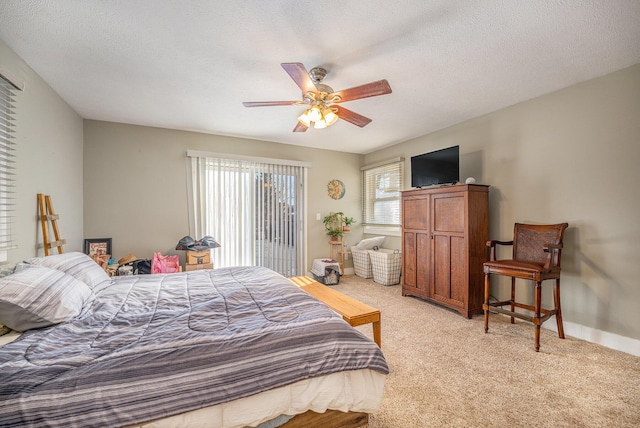 carpeted bedroom with multiple windows, a textured ceiling, and ceiling fan