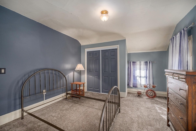 carpeted bedroom with vaulted ceiling and a closet