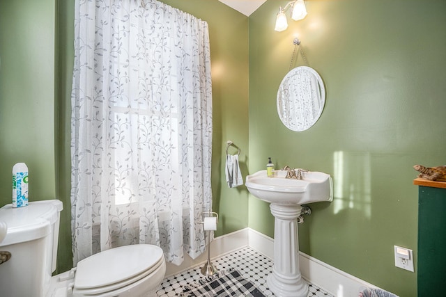 bathroom featuring toilet and tile patterned flooring