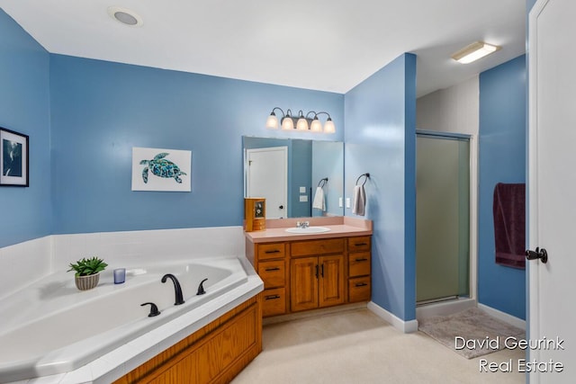 bathroom featuring a stall shower, a garden tub, and vanity