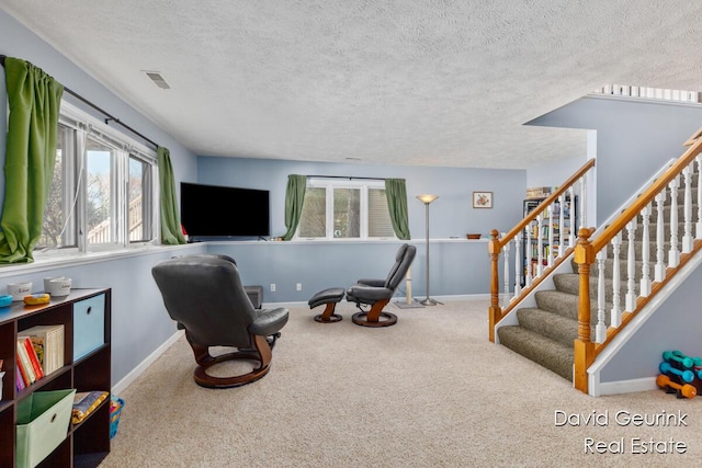 sitting room with baseboards, a textured ceiling, visible vents, and carpet flooring