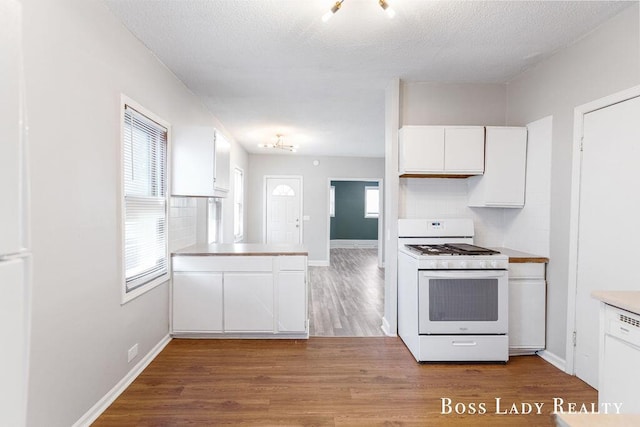 kitchen featuring white cabinetry, a wealth of natural light, and white appliances