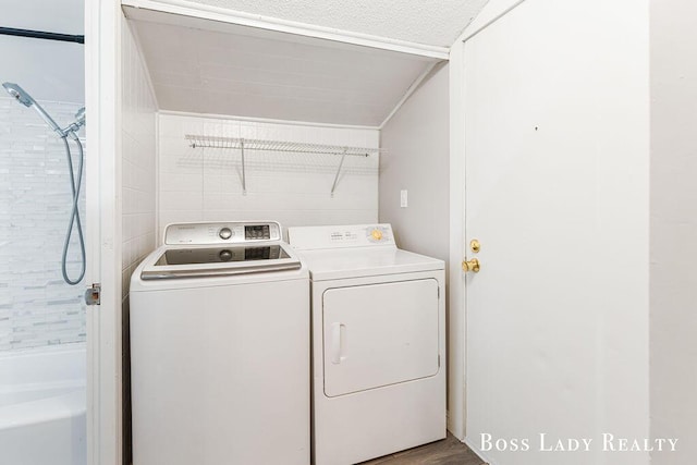 clothes washing area with hardwood / wood-style flooring and independent washer and dryer