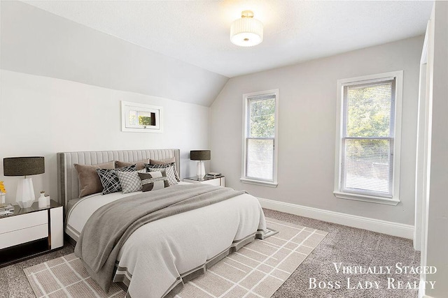 bedroom with lofted ceiling, light carpet, and multiple windows