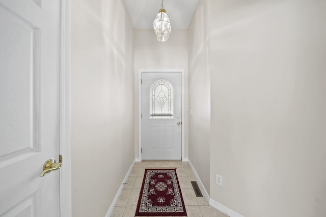 entryway with light tile patterned flooring and a notable chandelier