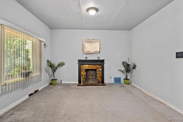 unfurnished living room with carpet flooring and a fireplace