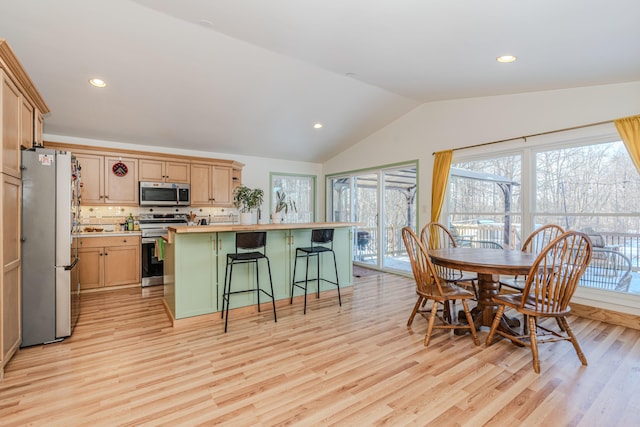 dining area featuring lofted ceiling and light hardwood / wood-style floors