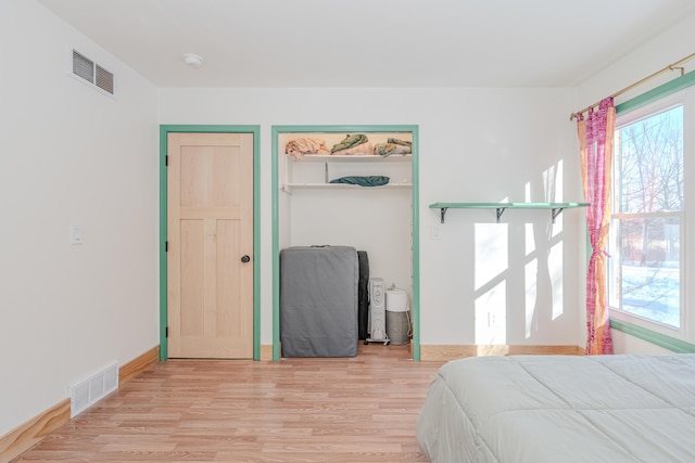 bedroom with light hardwood / wood-style flooring and a closet