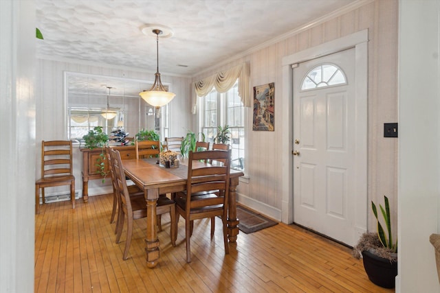 dining room with light hardwood / wood-style flooring and ornamental molding