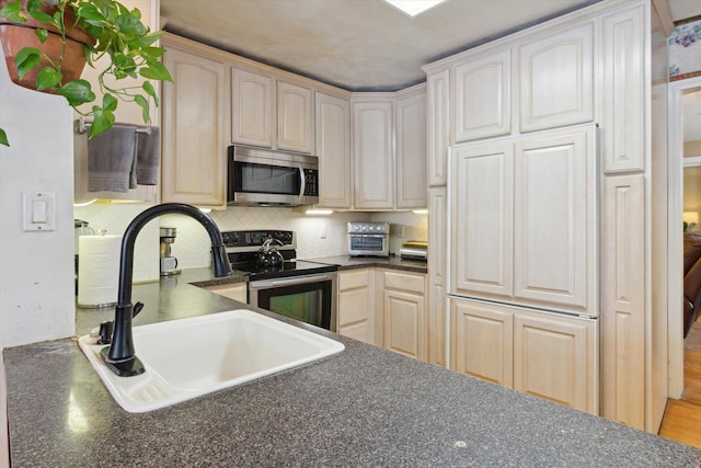 kitchen featuring stainless steel appliances, sink, and decorative backsplash