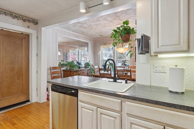 kitchen with sink, crown molding, light hardwood / wood-style flooring, backsplash, and stainless steel dishwasher