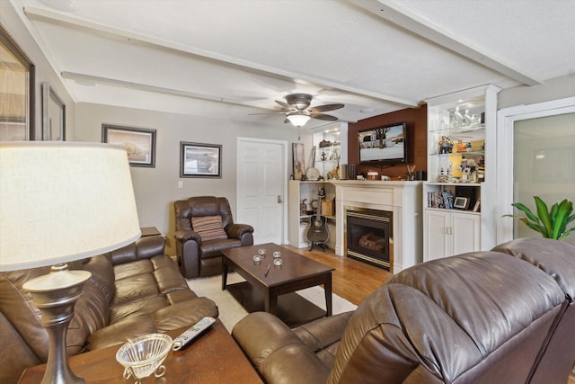 living room with beamed ceiling, wood-type flooring, and ceiling fan