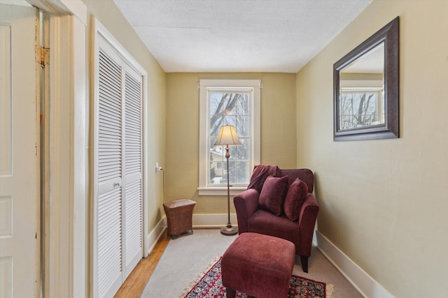 sitting room featuring light hardwood / wood-style flooring and a textured ceiling