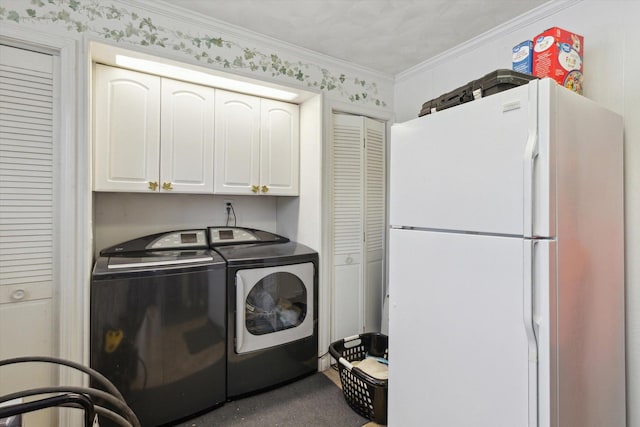 laundry area with crown molding, washer and clothes dryer, and cabinets