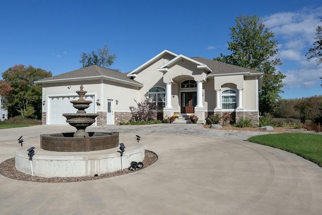 view of front of property with concrete driveway, stucco siding, and stone siding