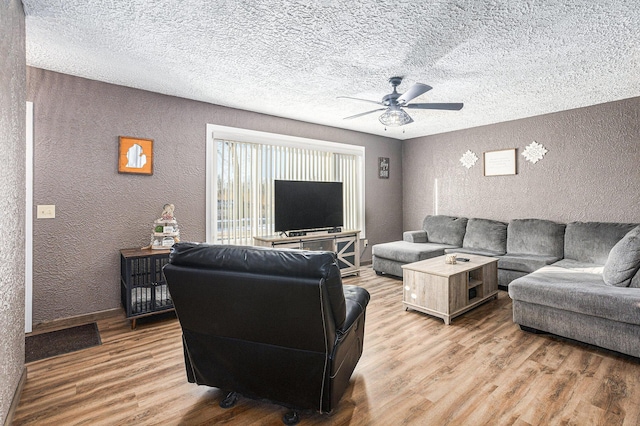 living room with hardwood / wood-style floors, a textured ceiling, and ceiling fan