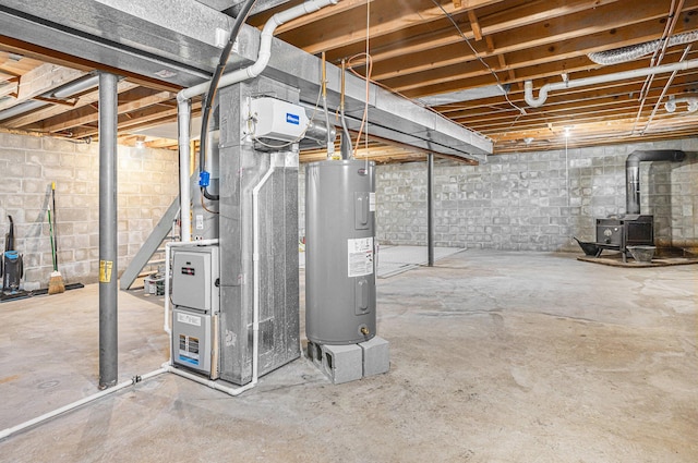 basement featuring heating unit, electric water heater, and a wood stove