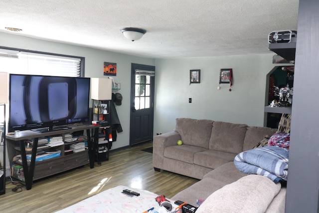 living room featuring wood-type flooring and a textured ceiling