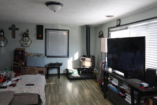 interior space featuring hardwood / wood-style floors, a textured ceiling, and a wood stove