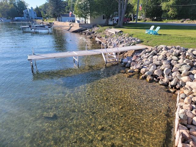 dock area with a lawn and a water view