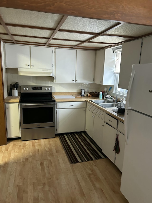 kitchen featuring white refrigerator, white cabinetry, sink, and stainless steel electric range