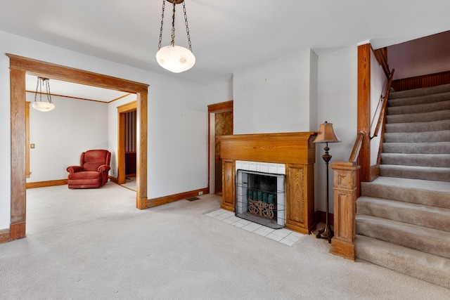 unfurnished living room with light colored carpet and a tile fireplace