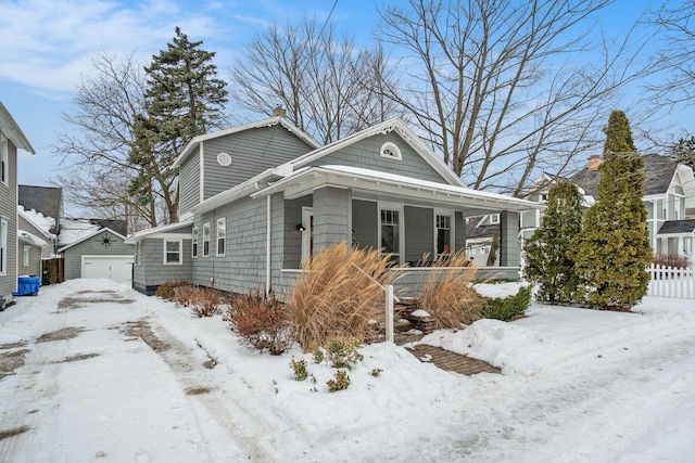 view of front of home featuring a garage, an outdoor structure, and a porch