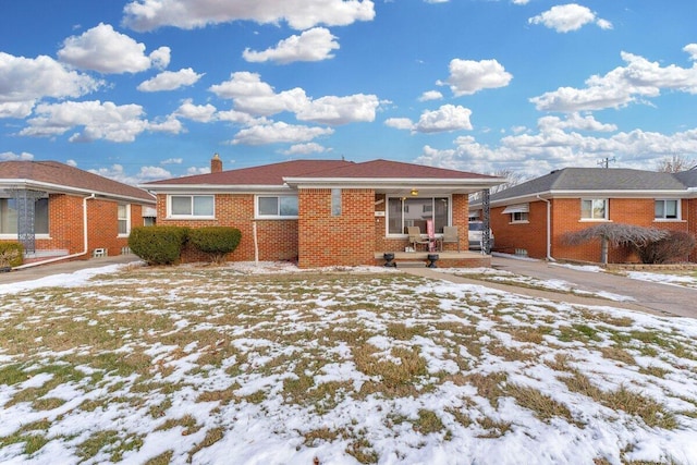 view of front of home featuring a chimney and brick siding