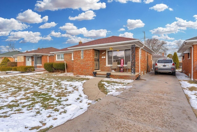 view of front facade featuring a chimney, a porch, concrete driveway, and brick siding