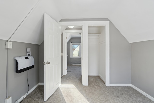 bonus room featuring light colored carpet, lofted ceiling, and heating unit