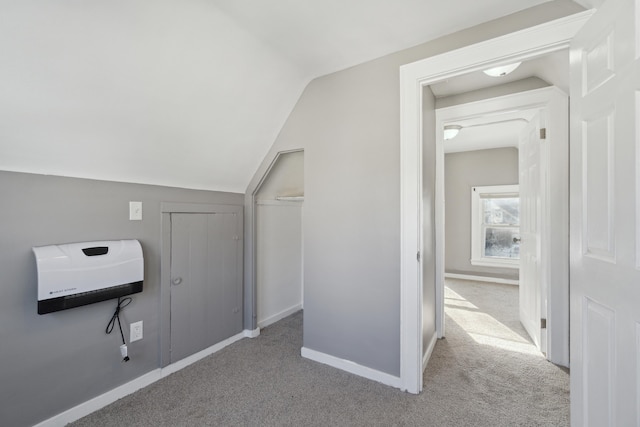 additional living space featuring lofted ceiling and light carpet