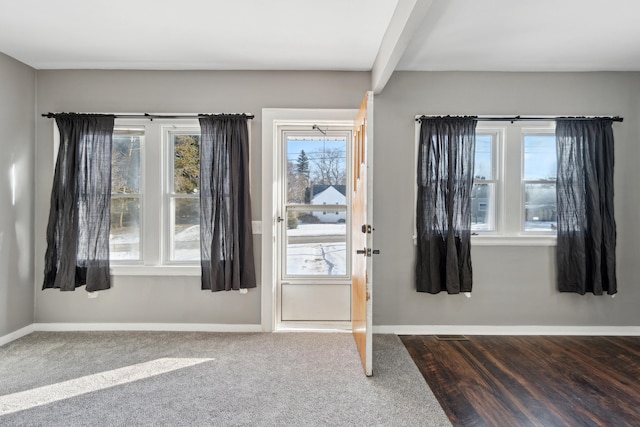 entrance foyer with beamed ceiling and carpet