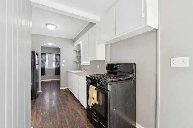 kitchen featuring dark hardwood / wood-style flooring, sink, black appliances, and white cabinets