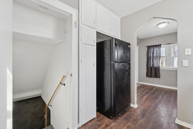 kitchen featuring black fridge, white cabinets, and dark hardwood / wood-style flooring