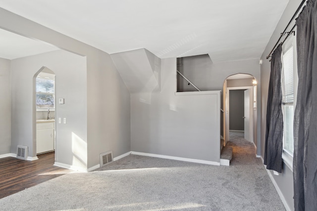 additional living space featuring sink and dark carpet