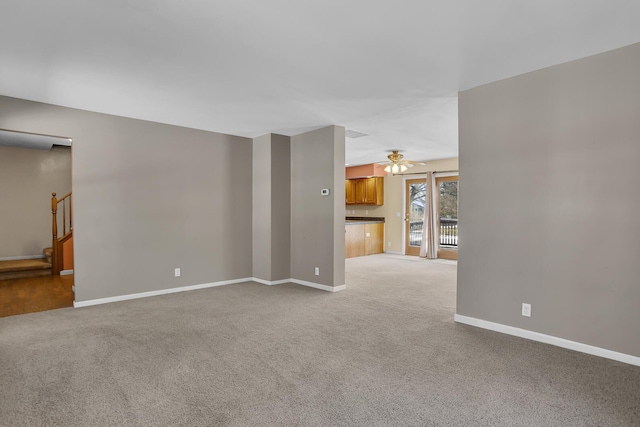 carpeted spare room featuring ceiling fan