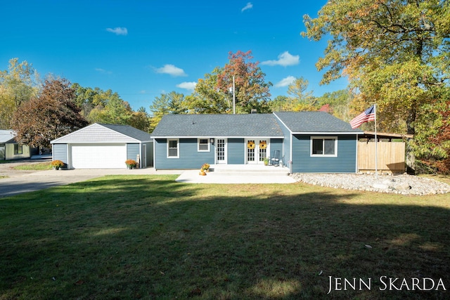 ranch-style house featuring an outbuilding, a garage, and a front lawn