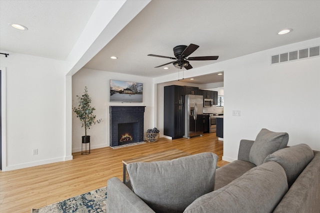 24112 N Shore Dr, Edwardsburg, MI 49112 - living area featuring light wood finished floors, a brick fireplace, visible vents, ceiling fan, and recessed lighting