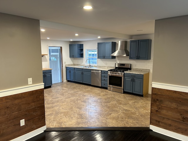 kitchen with wall chimney exhaust hood, sink, light wood-type flooring, appliances with stainless steel finishes, and decorative backsplash