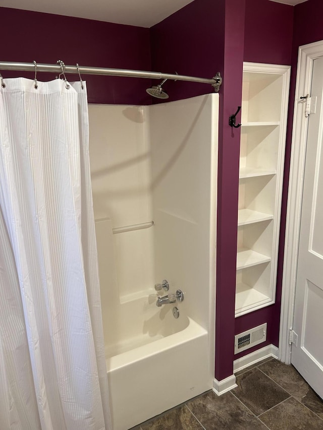 bathroom featuring built in shelves and shower / bathtub combination with curtain