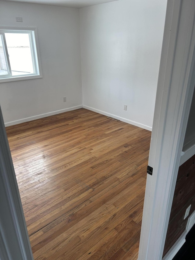 spare room with hardwood / wood-style flooring