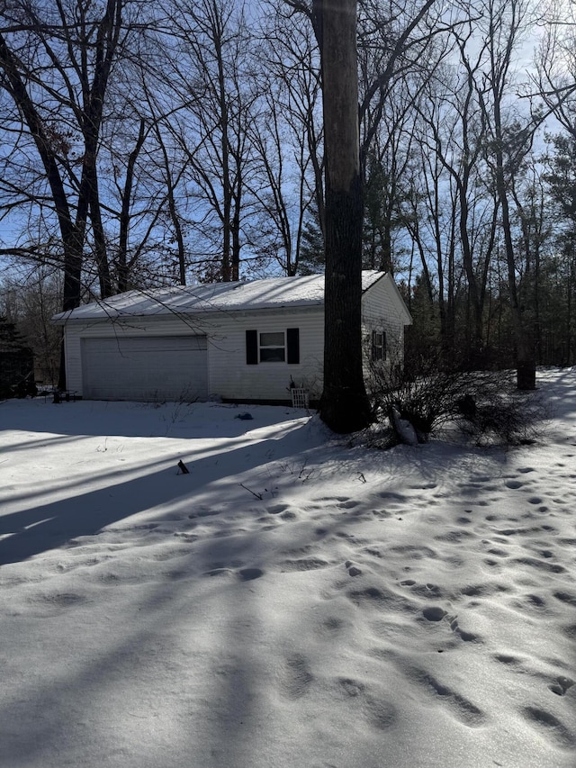 view of snowy exterior featuring a garage