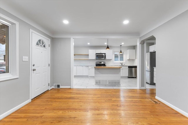 unfurnished living room with sink and light hardwood / wood-style floors