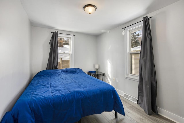 bedroom featuring light hardwood / wood-style floors and multiple windows