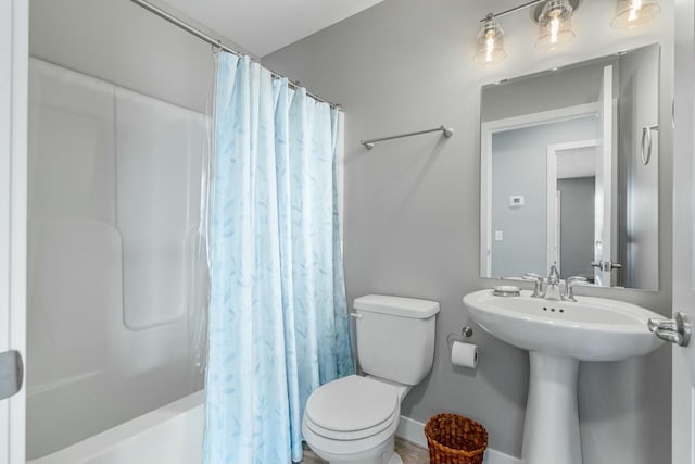 full bath with shower / tub combo, toilet, and a sink