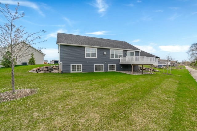 back of property with a wooden deck and a lawn