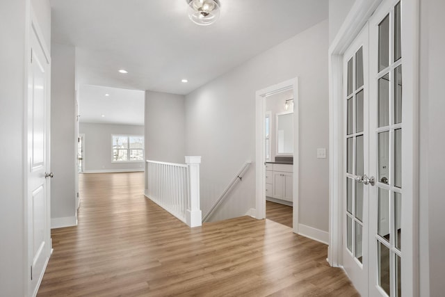 hallway with french doors and light hardwood / wood-style floors