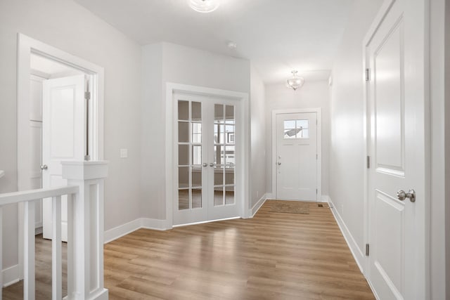 doorway with light wood-type flooring and french doors